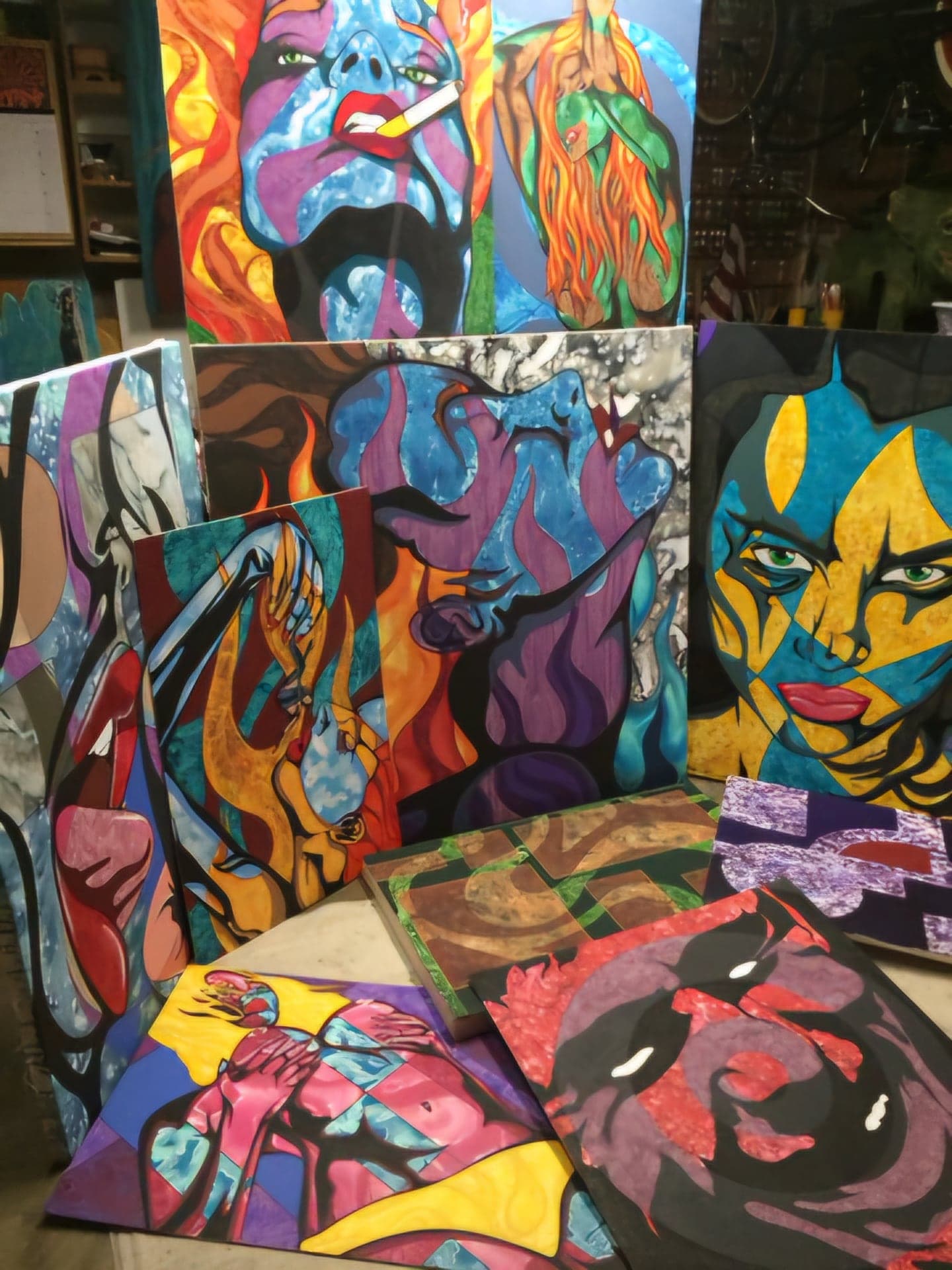 Finished canvases stacked and leaning together in the studio.