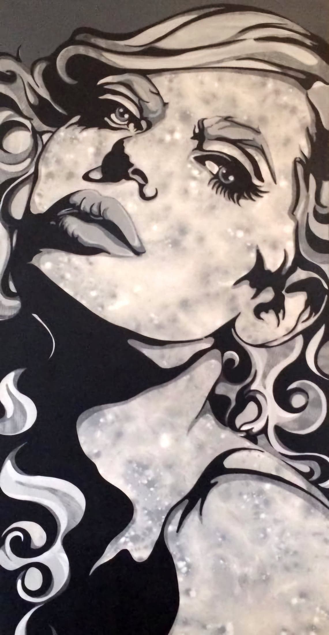 A face turned upward in black, white and silver, the hair dissolving into pale smoke.